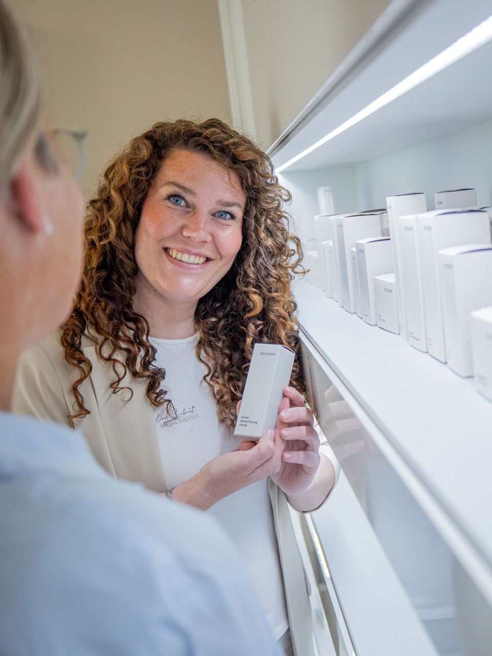 Eine Frau zeigt einem Mann eine weiße Box mit einem Produkt darauf