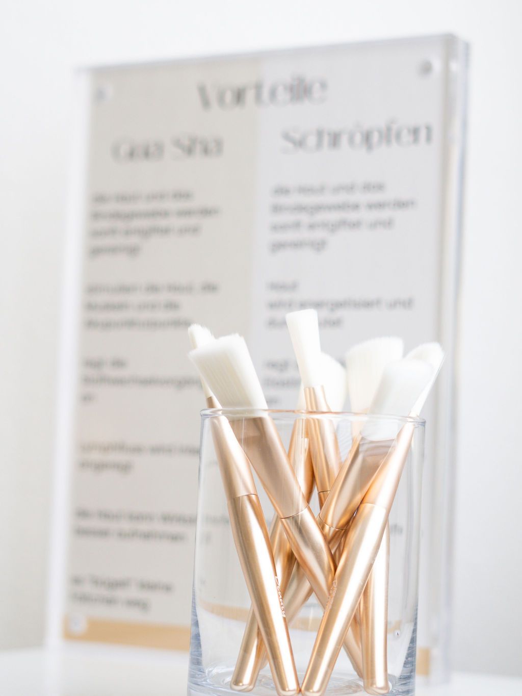 Ein mit Pinseln gefülltes Glas steht auf einem Tisch