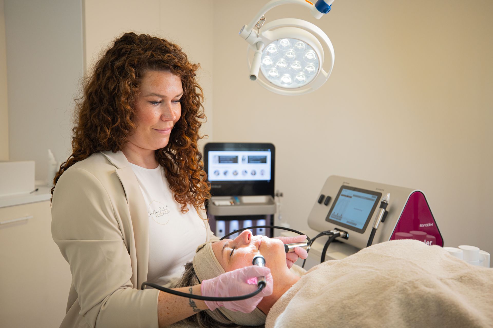Eine Frau verwendet eine Maschine im Gesicht eines Patienten.