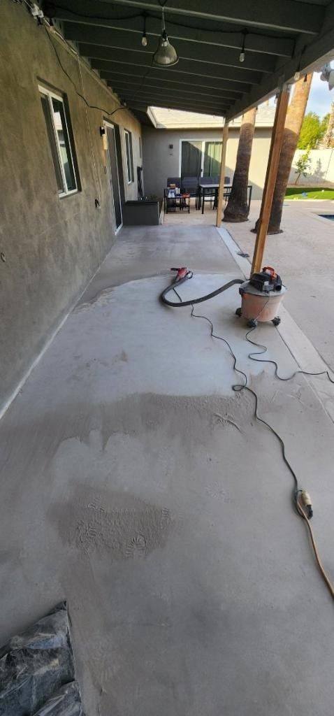 A vacuum cleaner is sitting on a concrete patio next to a house.