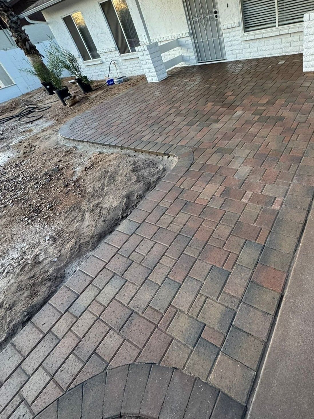 A brick walkway is being built in front of a house.