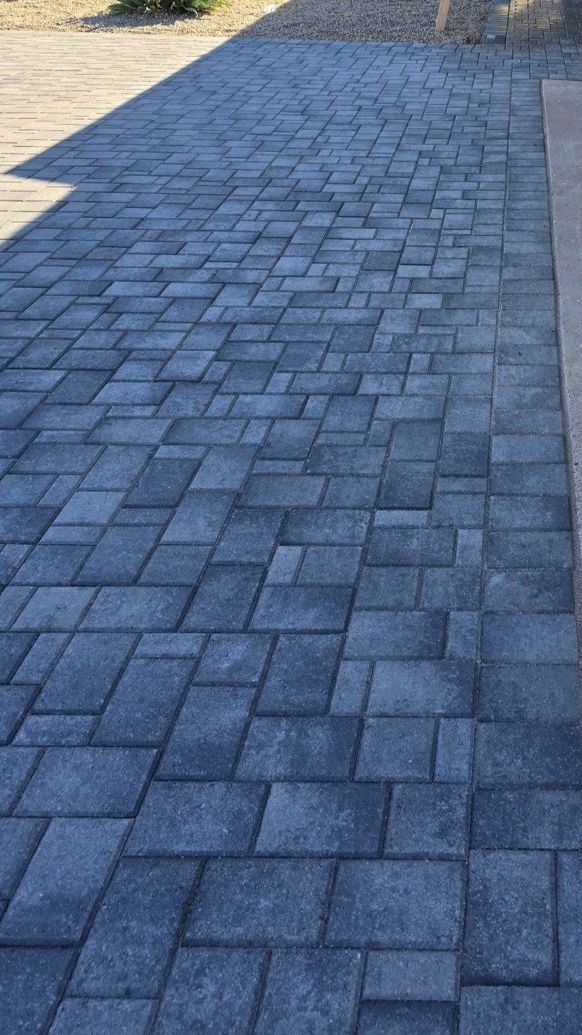 A close up of a brick walkway with a shadow on it.