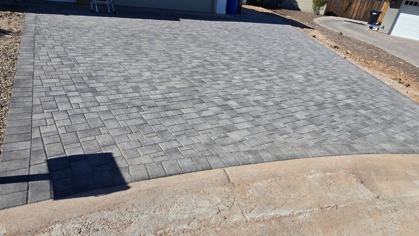 A brick driveway is being built in front of a house.