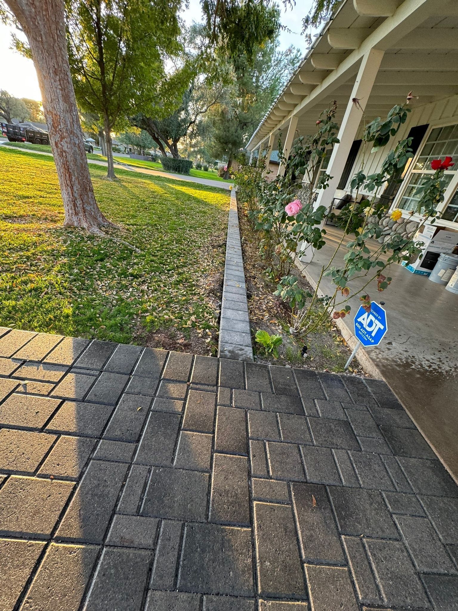 A brick walkway leading to a porch of a house.