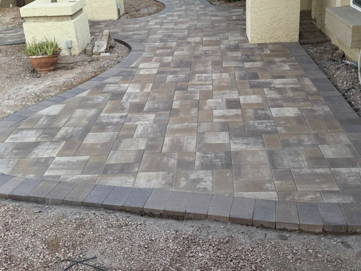 A brick walkway is being built in front of a house.
