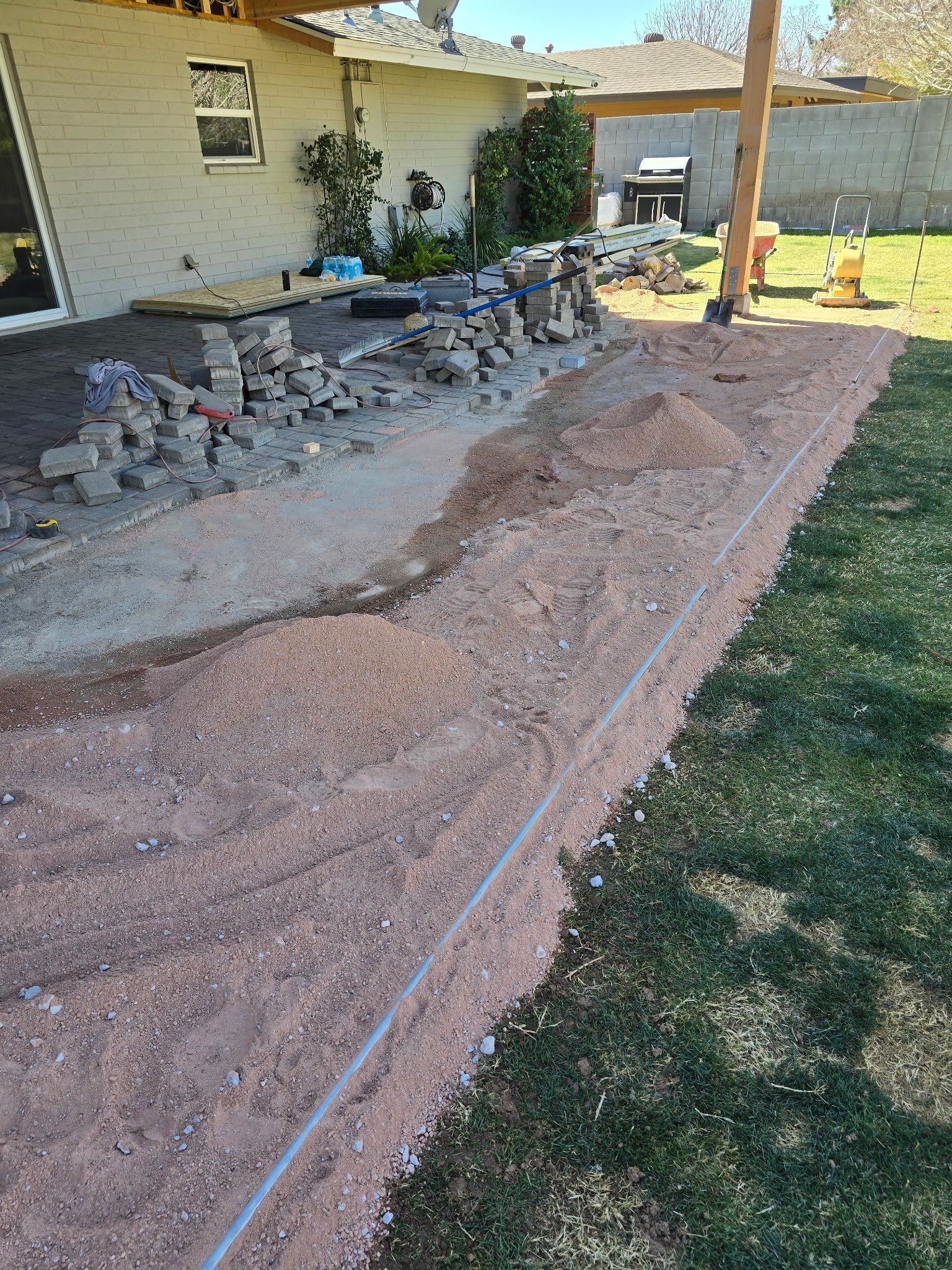 A dirt path is being built in the backyard of a house.