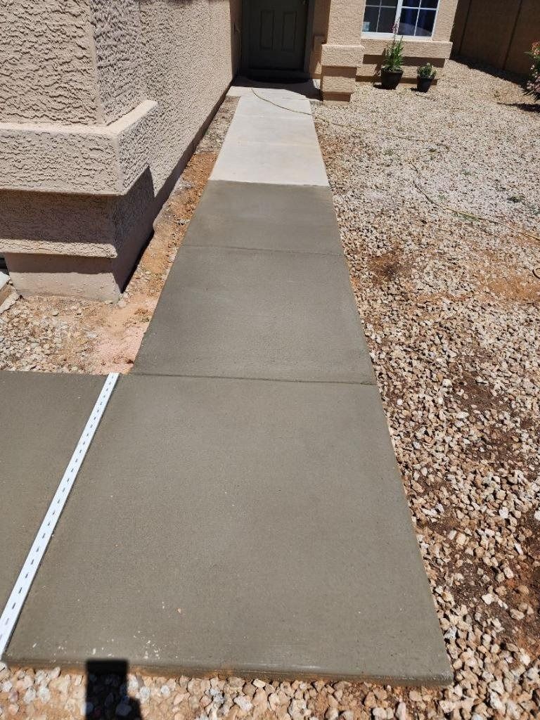 A concrete walkway leading to the front door of a house.