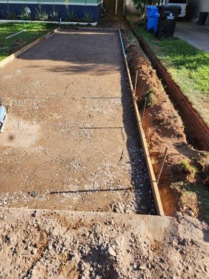 A concrete driveway is being built in front of a house.