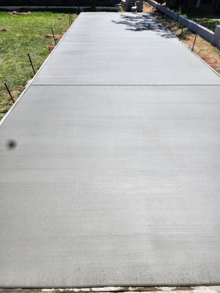 A concrete driveway is being built in a backyard.