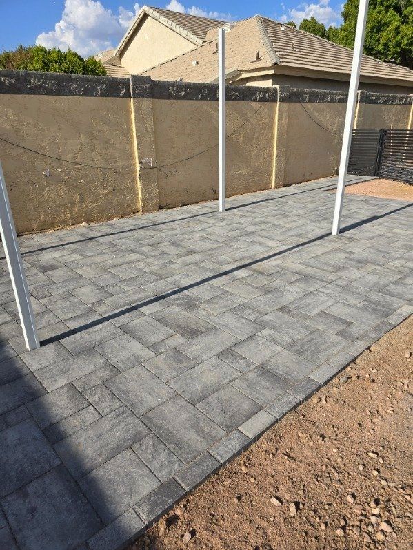 A patio with a fence and a house in the background.