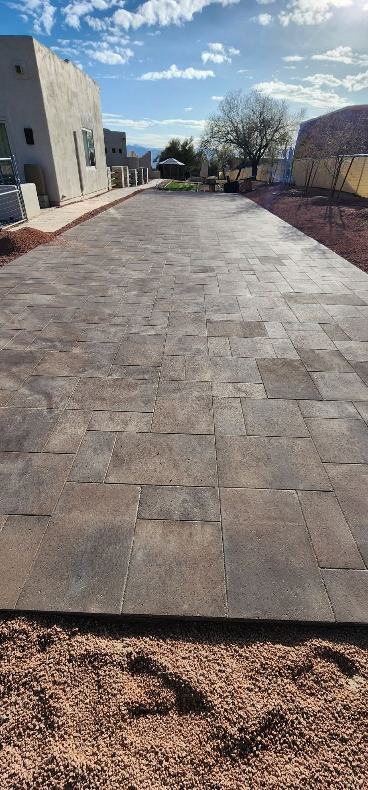 A long concrete driveway with a building in the background.