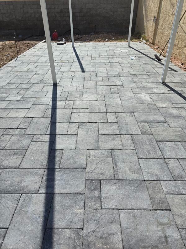 A patio with a swing set and a shadow of a person on it.