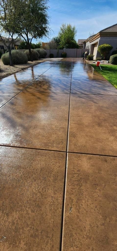 A concrete driveway with a puddle of water in the middle of it.