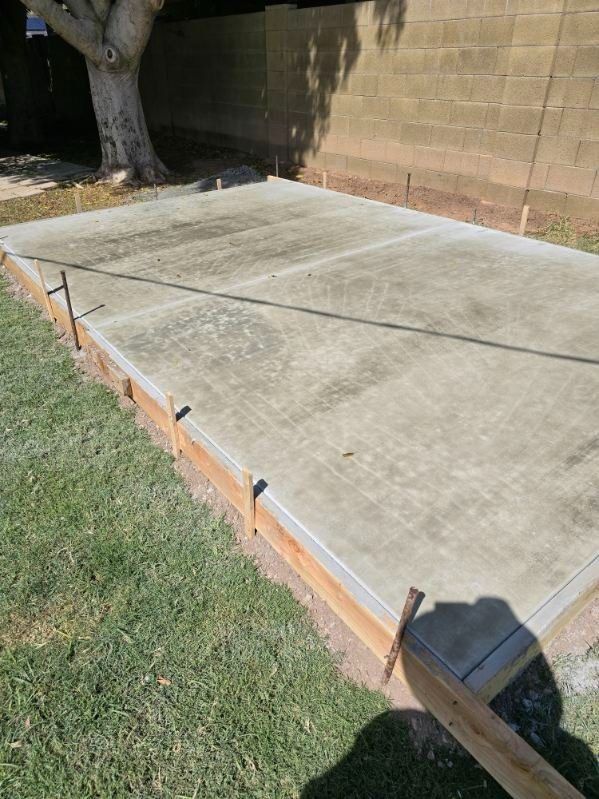 A concrete driveway is being built in front of a house.