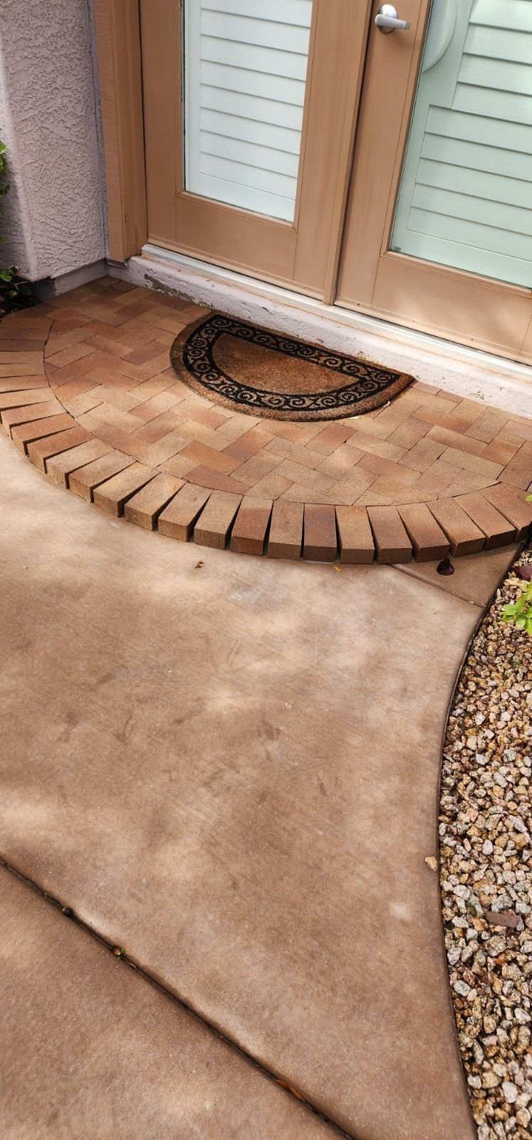 A door mat is sitting on the ground next to a door.