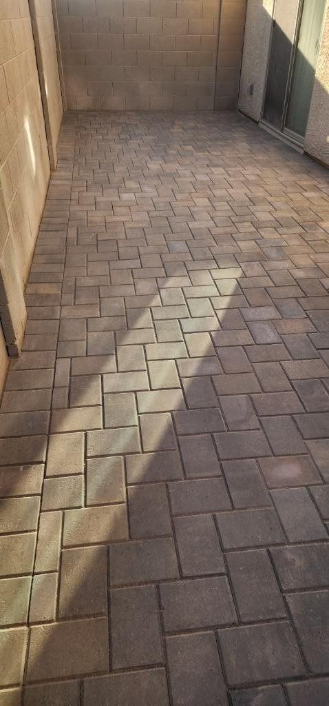 A brick walkway with a shadow of a person on it.