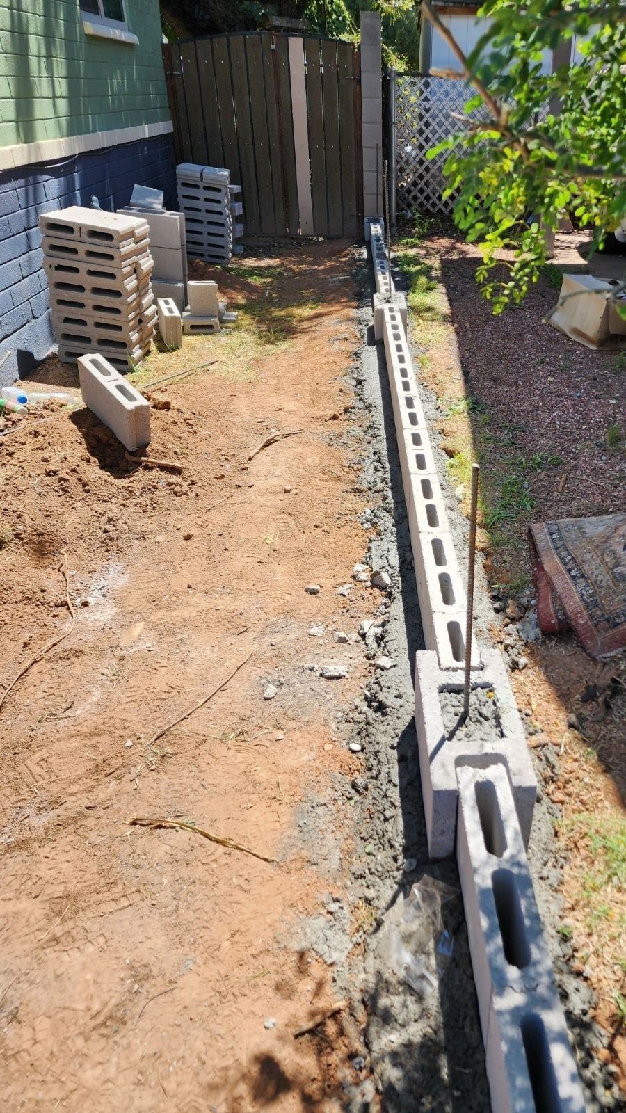 A fence is being built in the backyard of a house.