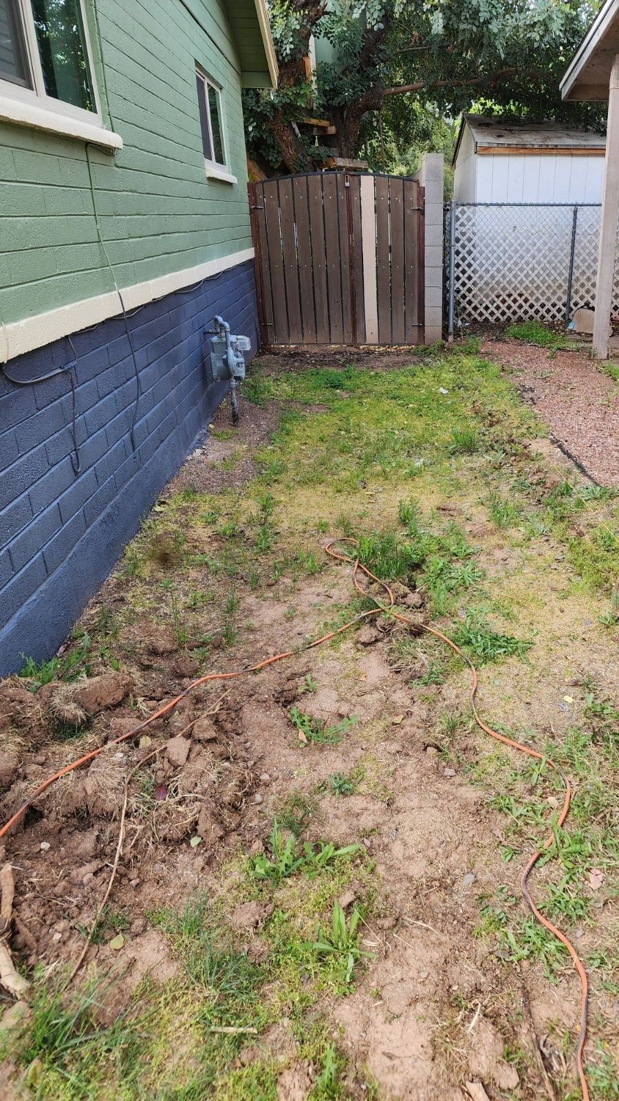 There is a fence in the backyard of a house.