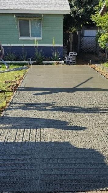 A concrete driveway is being built in front of a house.