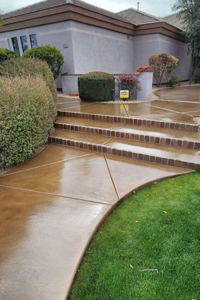 A concrete walkway with steps leading up to a house.