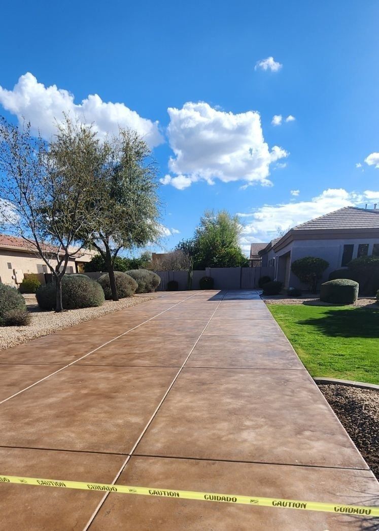 A concrete driveway leading to a house on a sunny day