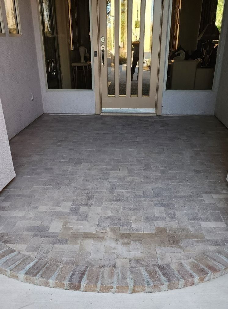 A brick walkway leading to a door in a house