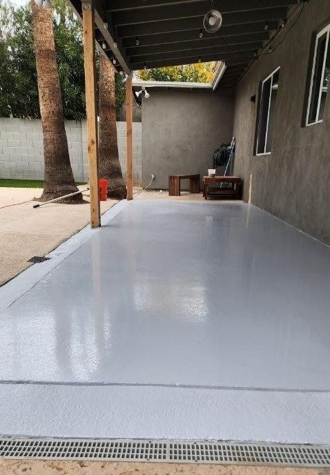 A garage with a covered patio and a concrete floor.