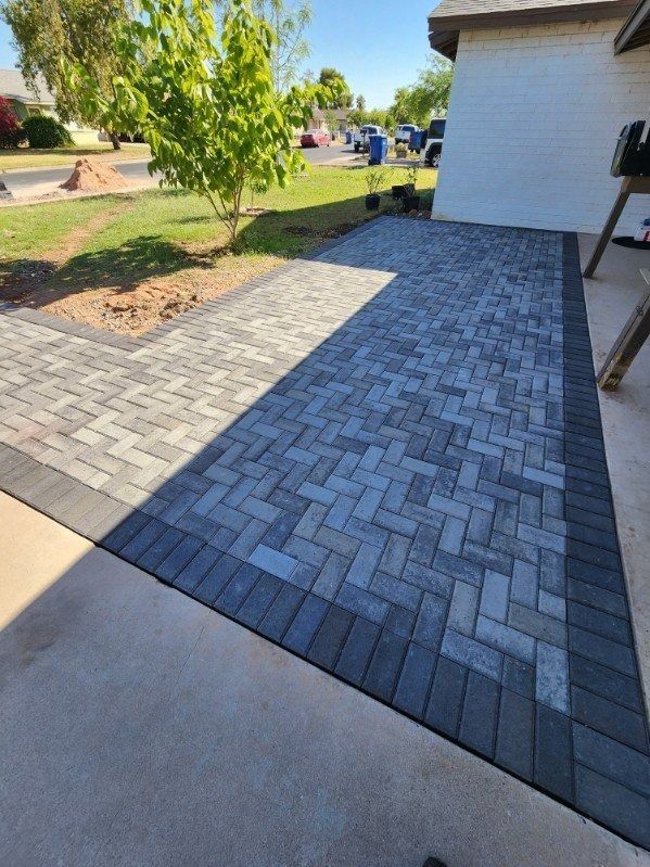 A brick walkway is being built in front of a house.