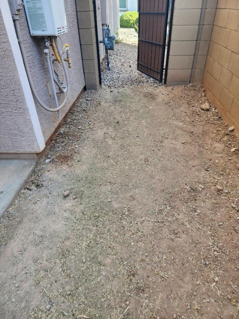 A dirt path leading to a house with a gate.