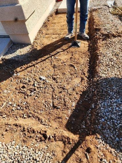 A person is digging a hole in the ground with a shovel.