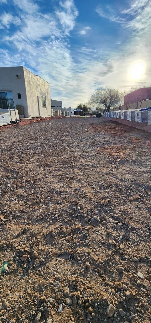 A large dirt field with a building in the background.