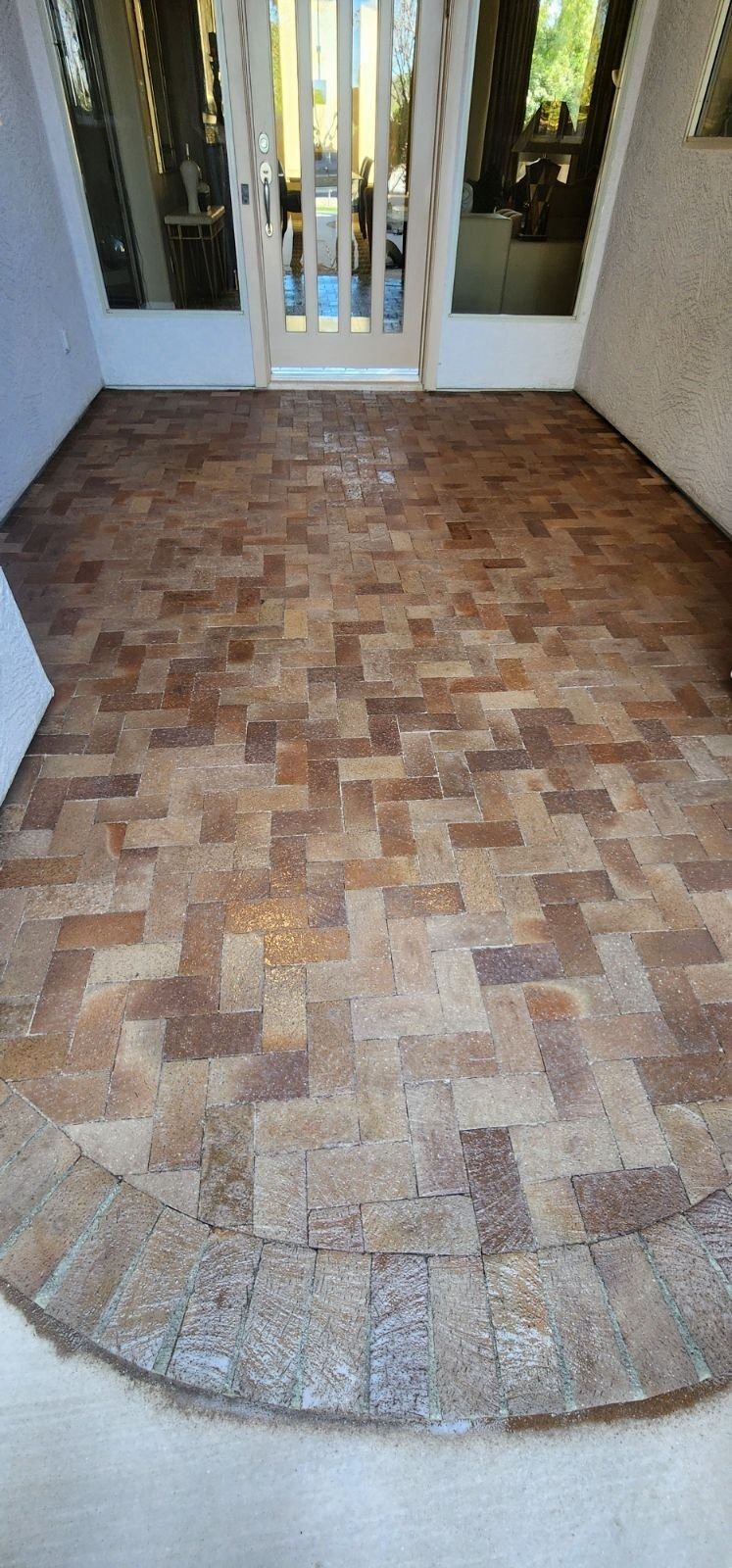 A patio with bricks and a door in a house.