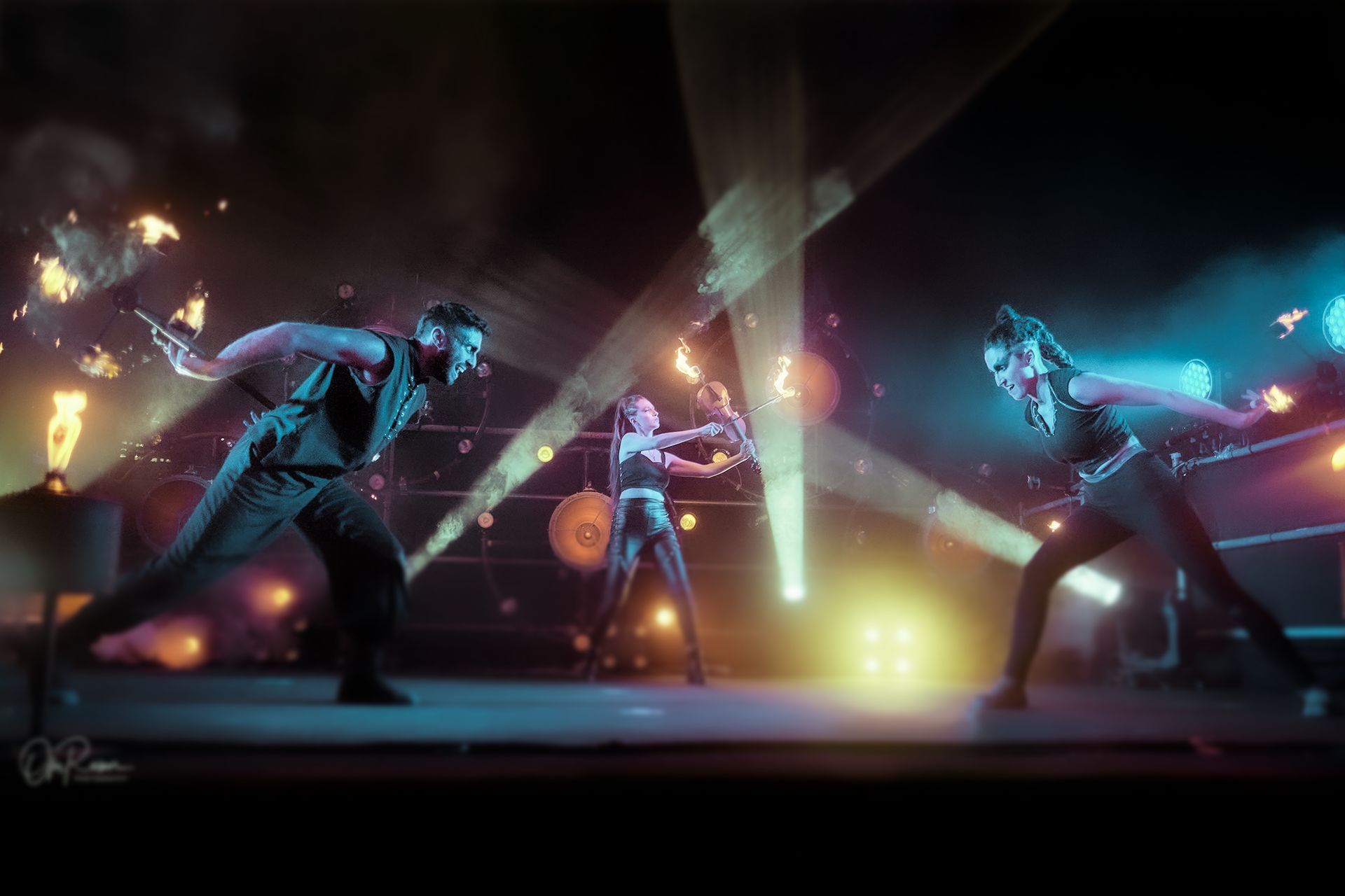 A group of people are performing a fire show on a stage.