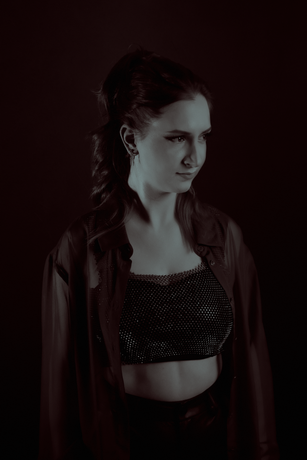 A black and white photo of a woman in a crop top and jacket.