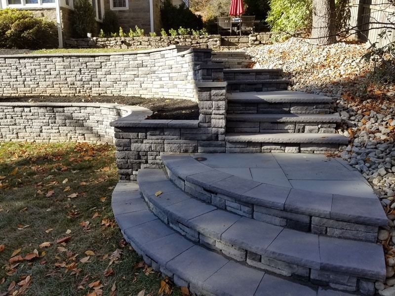 Stone steps lead up a hillside with stone retaining walls.