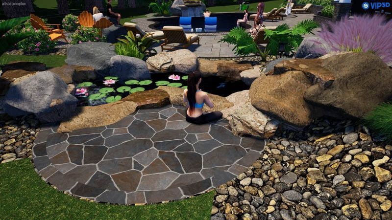 Person sits by a stone pond, surrounded by rocks and greenery in a backyard setting.