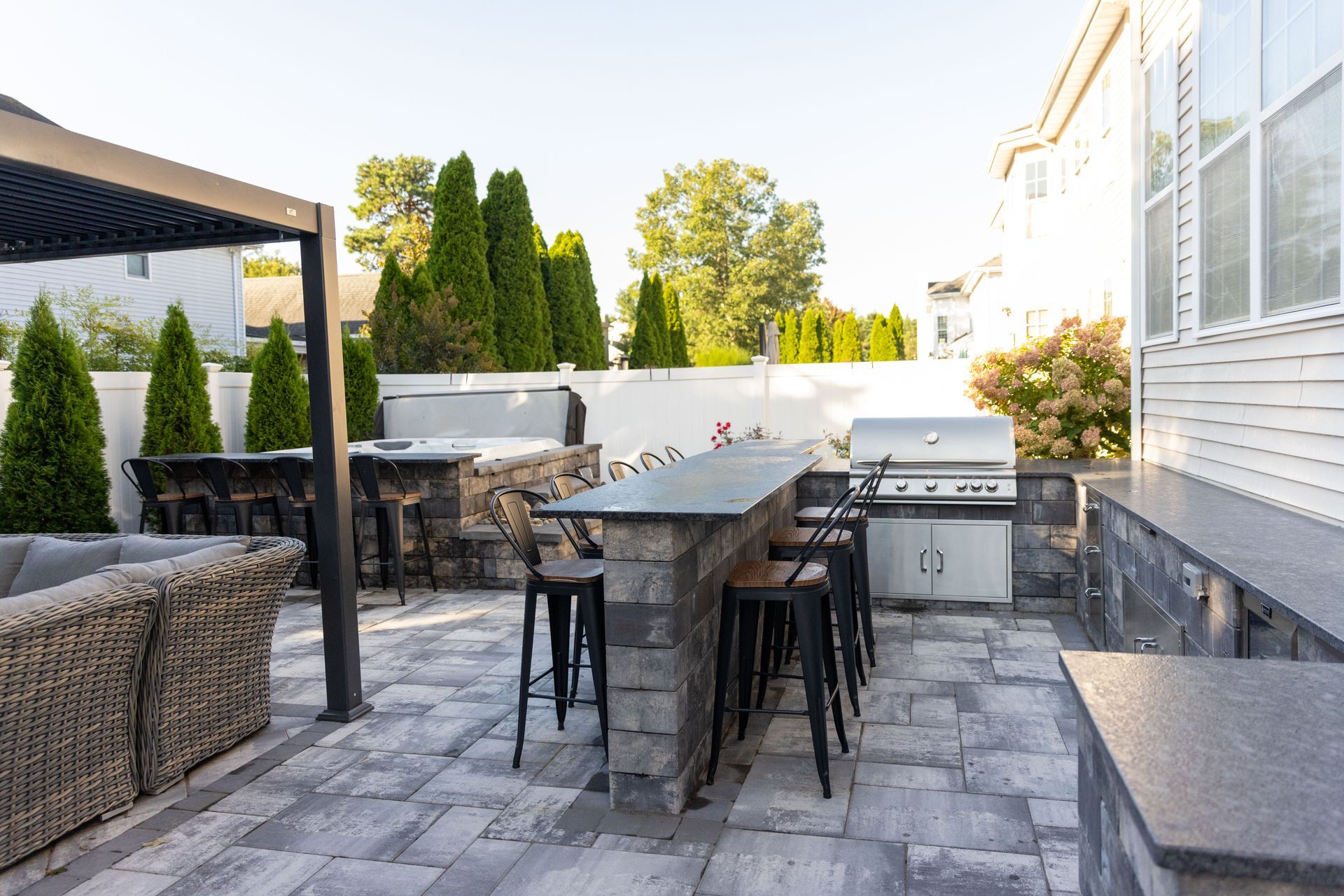 Outdoor patio with stone bar, grill, and seating area.
