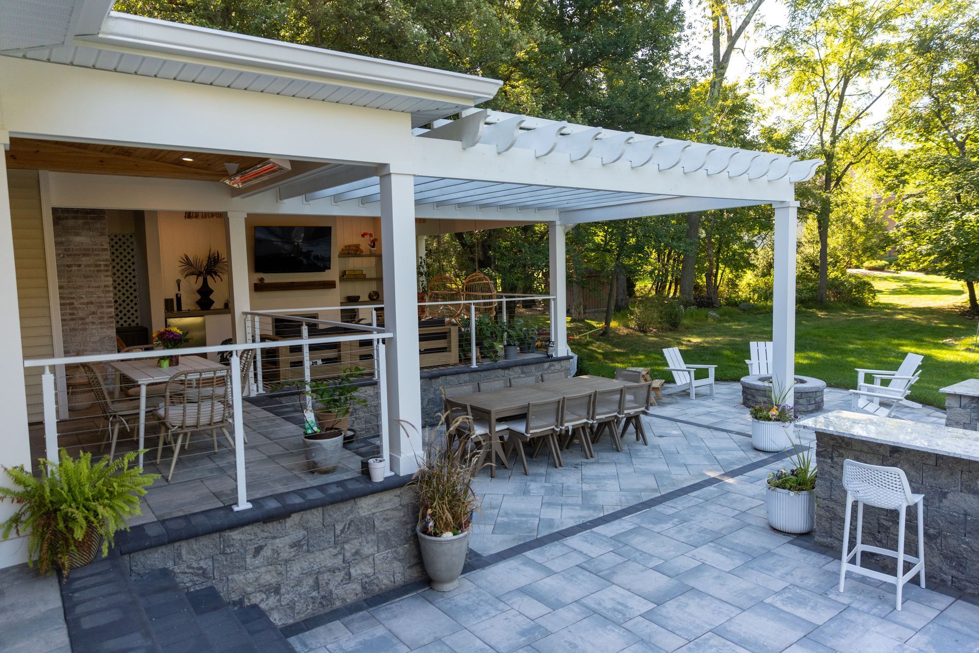 Outdoor patio with dining and bar areas, pergola, and stone accents.