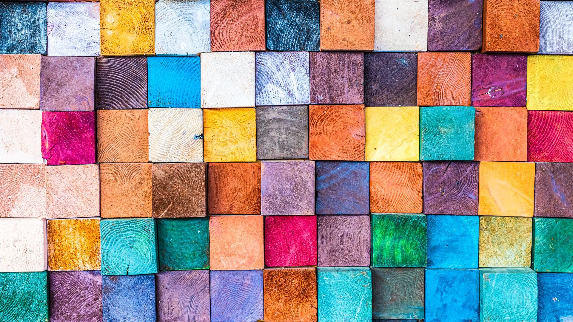 Colorful square wooden blocks arranged in a grid pattern.