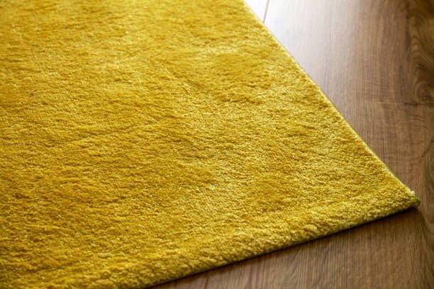The corner of a yellow carpet on top of a wooden floor - Macomb, MI - Night Owl Express Carpet Cleaning