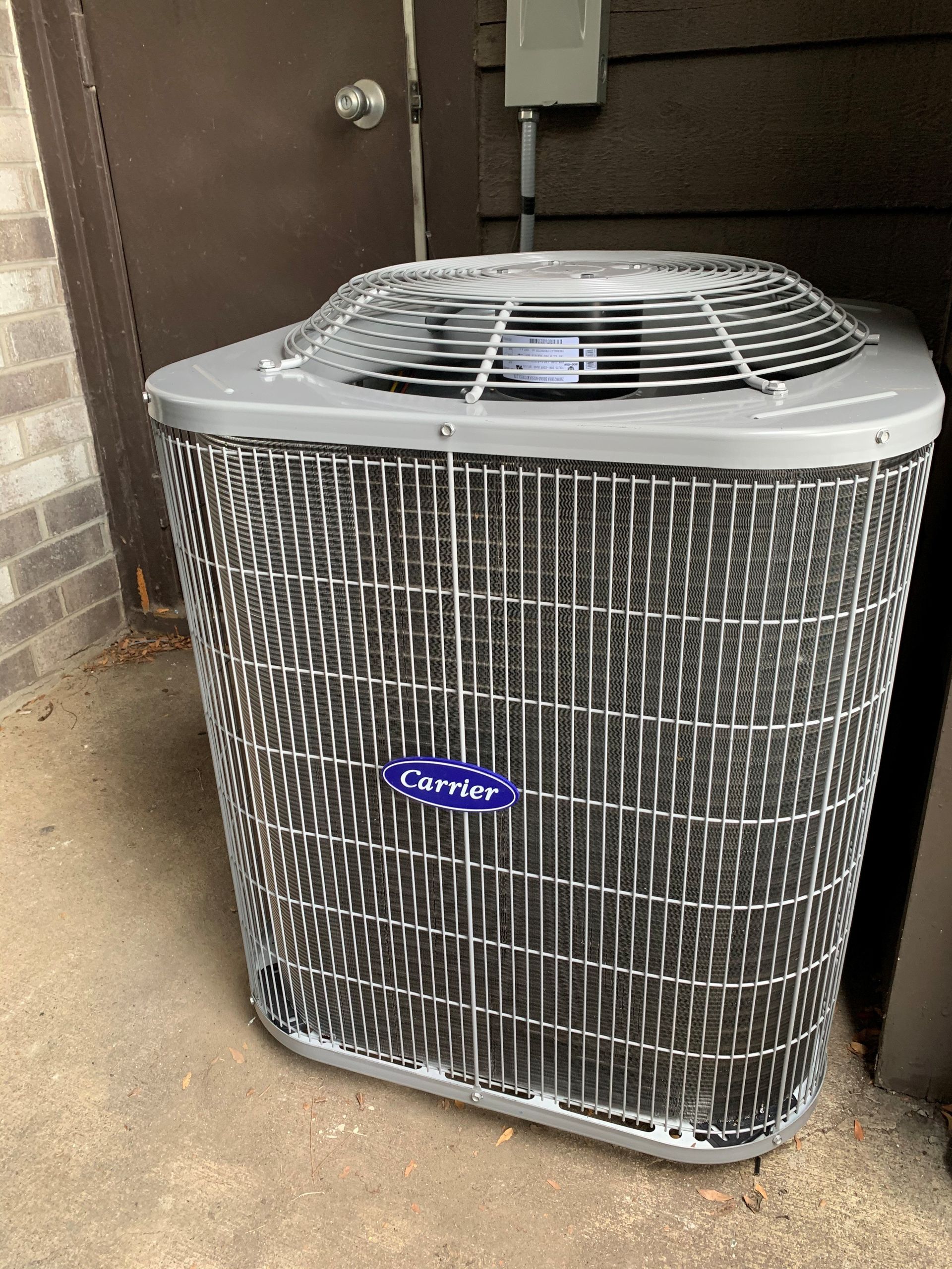 Carrier air conditioning unit outside a brown building.