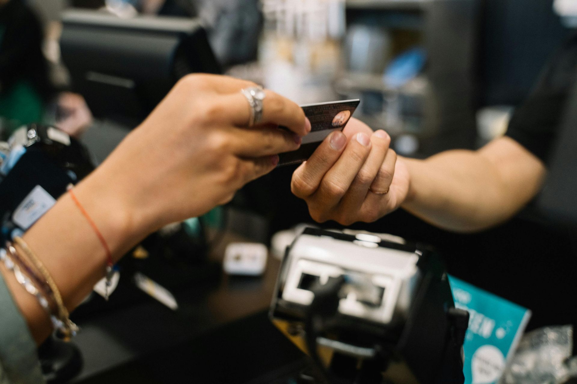 A woman is using a credit card reader in front of a computer.