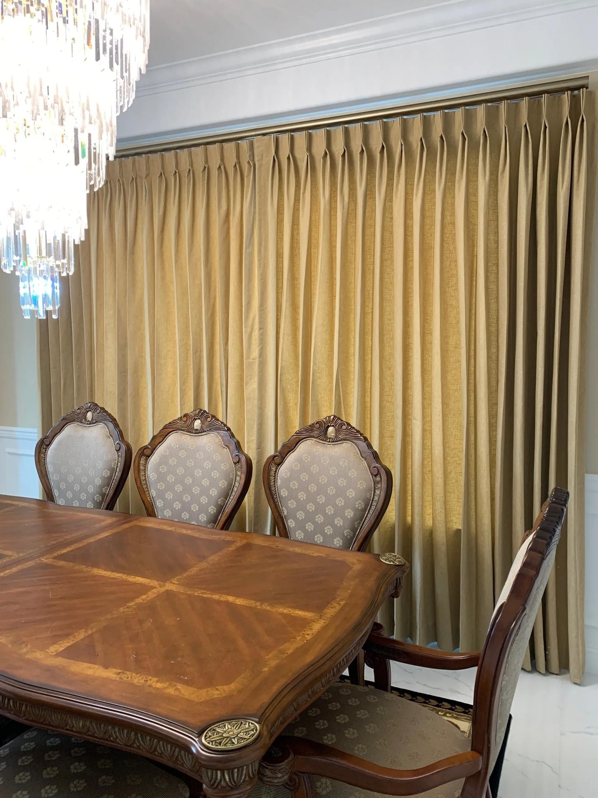 Elegant gold custom draperies installed in a traditional Seattle dining room, providing warmth and light control during winter.