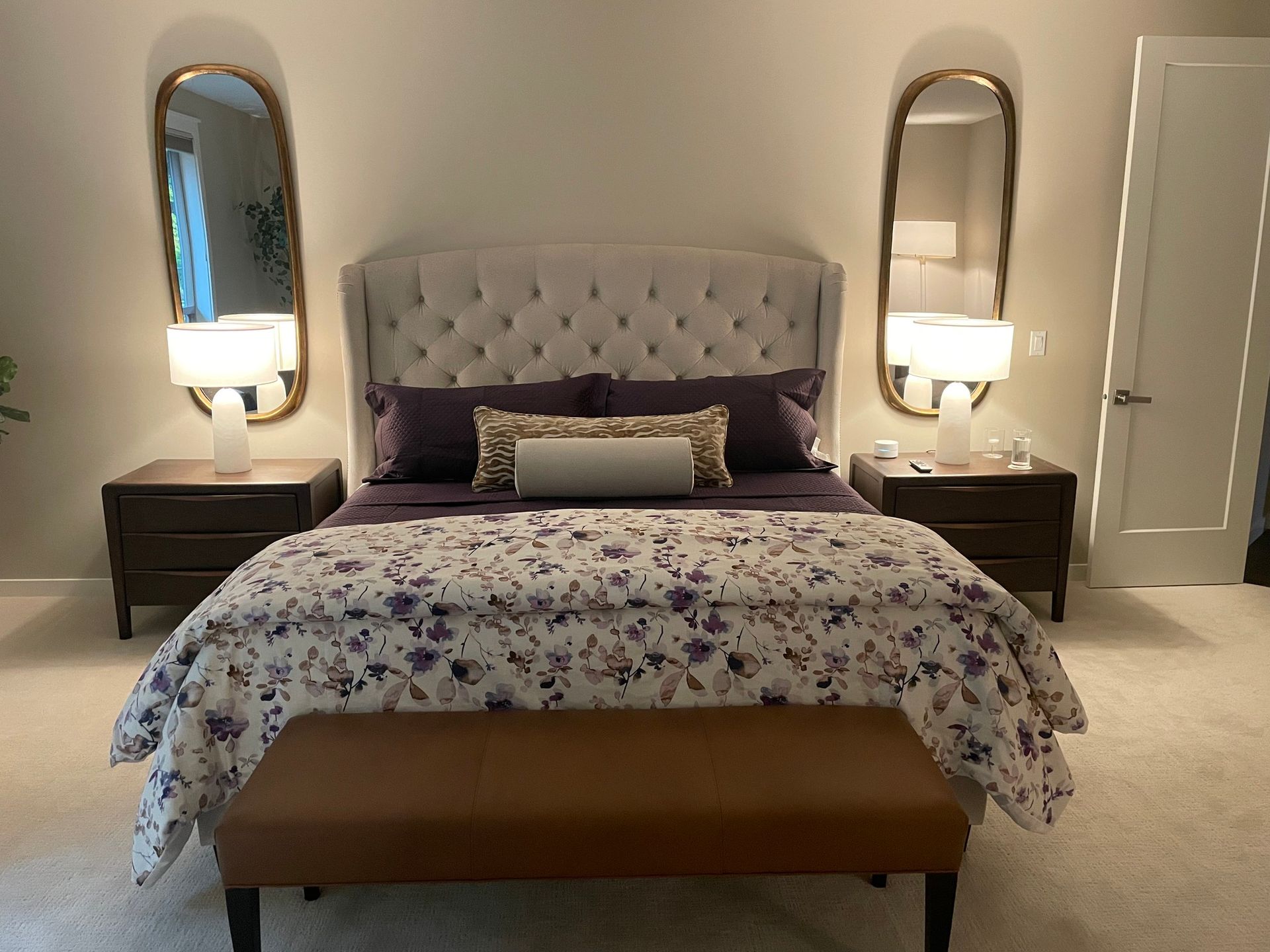 Custom bedding in a Seattle bedroom with a tufted headboard, floral duvet, layered pillows.