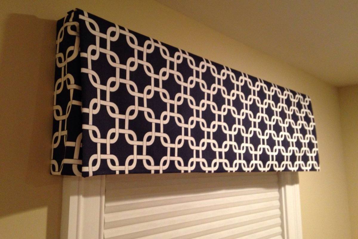 Fabric-covered custom cornices and valances in a black and white interlocking square pattern