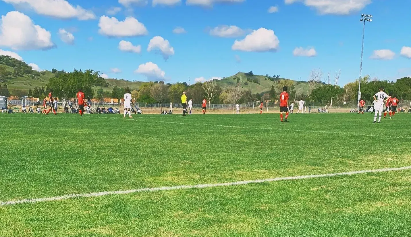 A soccer game being played at Horse Creek Soccer Complex - one team is wearing red and black, the other is wearing white