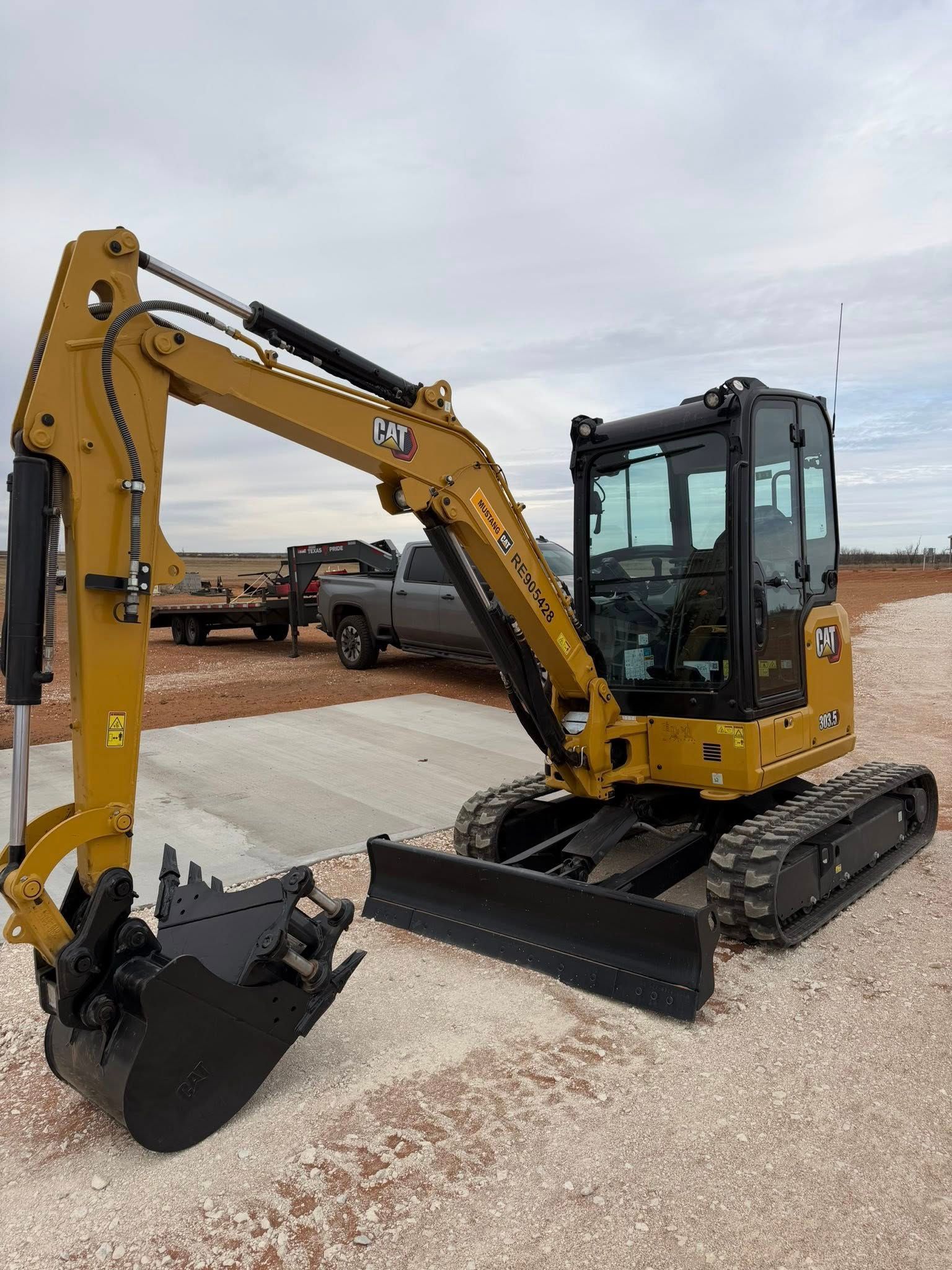 Yellow Caterpillar mini excavator on a construction site.
