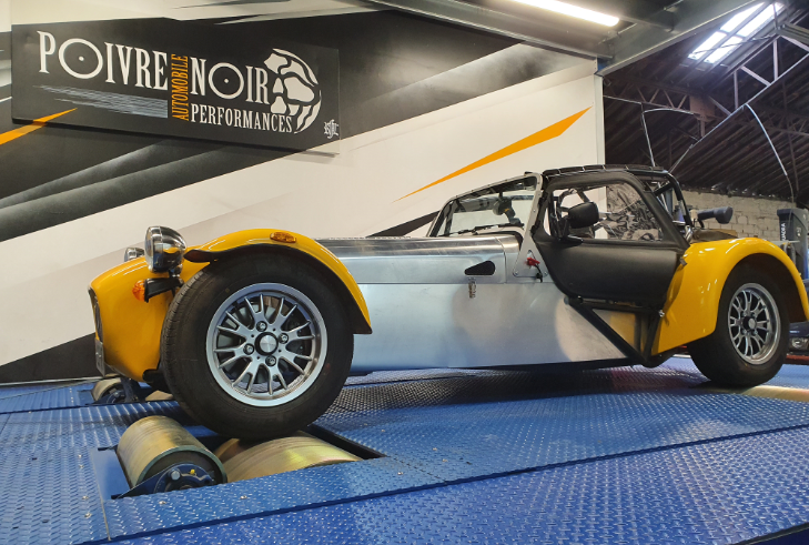 Voiture de sport jaune sur un banc d'essai, testée chez Poivre Noir Performance.