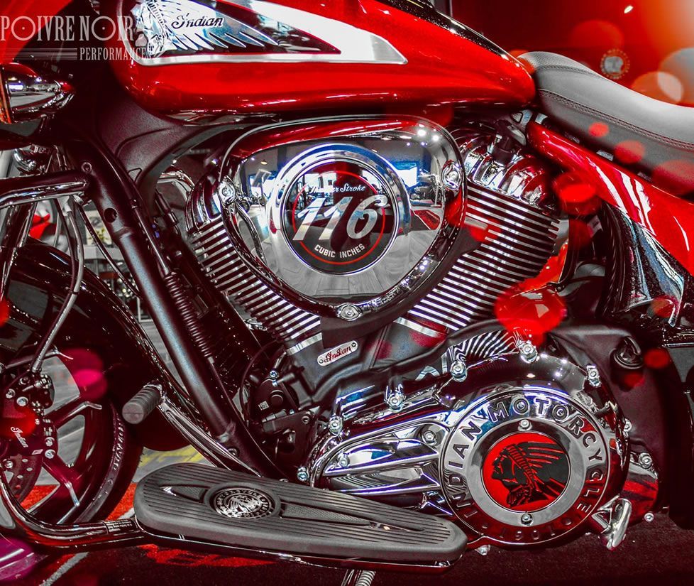 Moto indienne rouge et chromée avec des accents de cœur, exposée lors d'un événement.