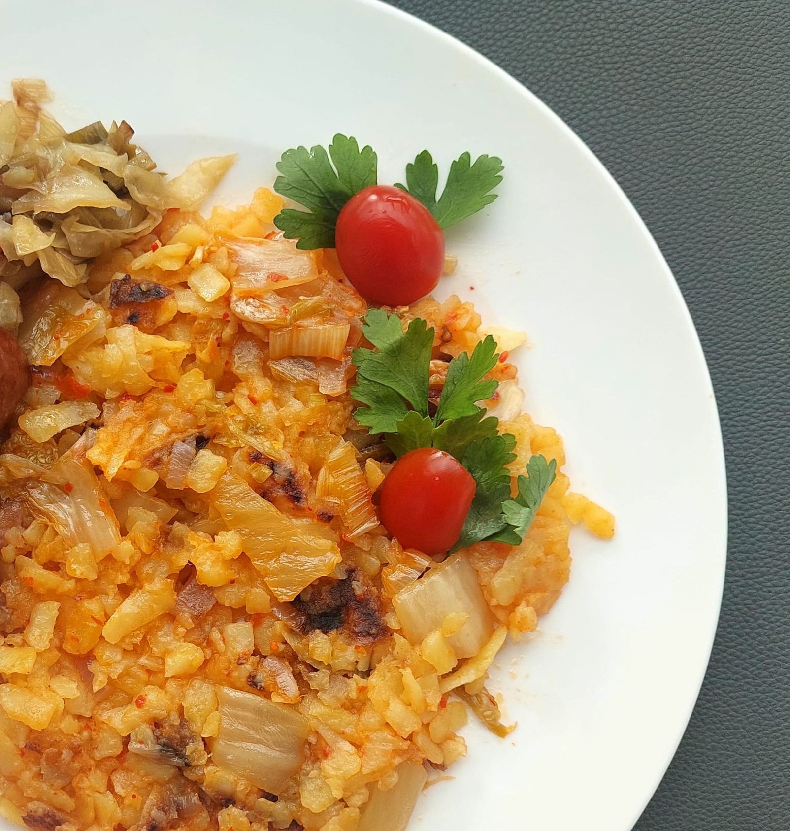 Une assiette blanche garnie de saucisses de riz et de tomates
